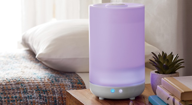 Small humidifier on a nightstand next to a bed