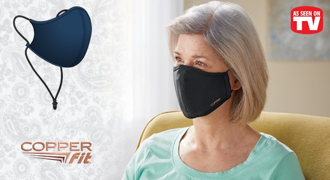 Woman seated in a chair and wearing a protective face mask; face mask off to the side with neck lanyard shown